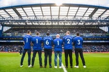 Former Chelsea players Gary Cahill, Jimmy Floyd Hasselbaink and Eiður Guðjohnsen (named shirts) and Chelsea fans (l-r) Marcus Cuthbert, Carlo Capelli, and Fabio Agostini show the Samaritans’ 24-hour helpline number 116 123 printed on the back of their shirts during the launch of the TalkMoreThanFootball campaign from Three, sponsors of Samaritans, during halftime of Chelsea vs Brighton at Stamford Bridge. Picture date: Saturday 15 April, 2023. PA Photo. The campaign aims to encourage fans to open up after new research reveals that British people are twice as likely to talk about football than their mental wellbeing. Picture credit should read: Matt Crossick/PA Wire.