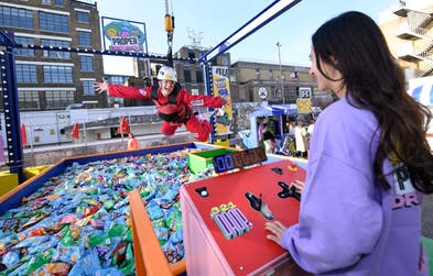 Amy Jane Hills demonstrates the ‘PROPER Dropper’, the UK’s first human claw arcade machine, ahead of its launch on October 28, giving people the chance to win free snacks and thousands of pounds worth of prizes. Issue date: Thursday October 27, 2022. PA Photo. Opening in Ely’s Yard, Shoreditch for two days only, The arcade machine contains a pit of 16,000 bags of PROPER Snacks, as well hidden gold packs with prizes from brands such as NICCE, ByRotation, FILA, and SONOS.