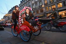 EDITORIAL USE ONLY Christy Bucklow on the Merchant Gourmet ‘Chestnut Chariot’, a rickshaw offering free rides to Christmas shoppers around central London to mark the expansion of the brand’s chestnut snack range. Issue date: Thursday November 24, 2022. PA Photo. The launch of the service, which offers riders a chestnut blanket to keep warm, chestnut snacks and chestnut-themed Christmas tunes, follows research showing that over a quarter of British people have never tried the historic festive snack.