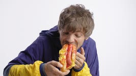 Louis Tomlinson eats a hotdog on LADbible's Snack Wars