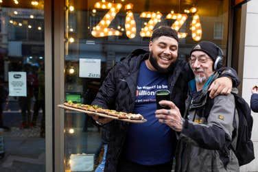 EDITORIAL USE ONLYBig Zuu gives out slices of ‘Big Zuu's Zillionaire Rustica’, a pizza he has designed exclusively for Zizzi to mark the launch of their Zillionaires’ Club loyalty platform, to members of the public on London’s The Strand. Picture date: Thursday November 2, 2022. PA Photo. Customers who sign up to the platform will rewarded with a free garlic bread, free food each time they visit, be able to use click and collect services, and purchase Zizzi for delivery. Big Zuu’s Zillionaire Rustica is now live on the menu nationwide.