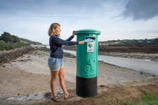 EDITORIAL USE ONLY Community Organiser Grace Fisher unveils a green post box that has been installed by The Climate Coalition on Porthkidney Sands in Cornwall as part of The Climate Coalition’s ‘Letters to Tomorrow’ campaign during this year’s ‘Big Green Week’ programme. Issue date: Tuesday September 27, 2022. PA Photo. The post boxes have been placed in various locations across the UK , including London, Manchester, Cardiff and Cornwall, to encourage the public to write letters addressing their hopes and fears about climate change in personal letters. As part of the campaign, one letter a day will be sent to a UK politician. Photo credit should read: Photo credit should read: Emily Whitfield-Wicks/PA Wire